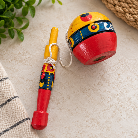 Hand-painted Colombian coca cup-and-ball toy on a light tabletop