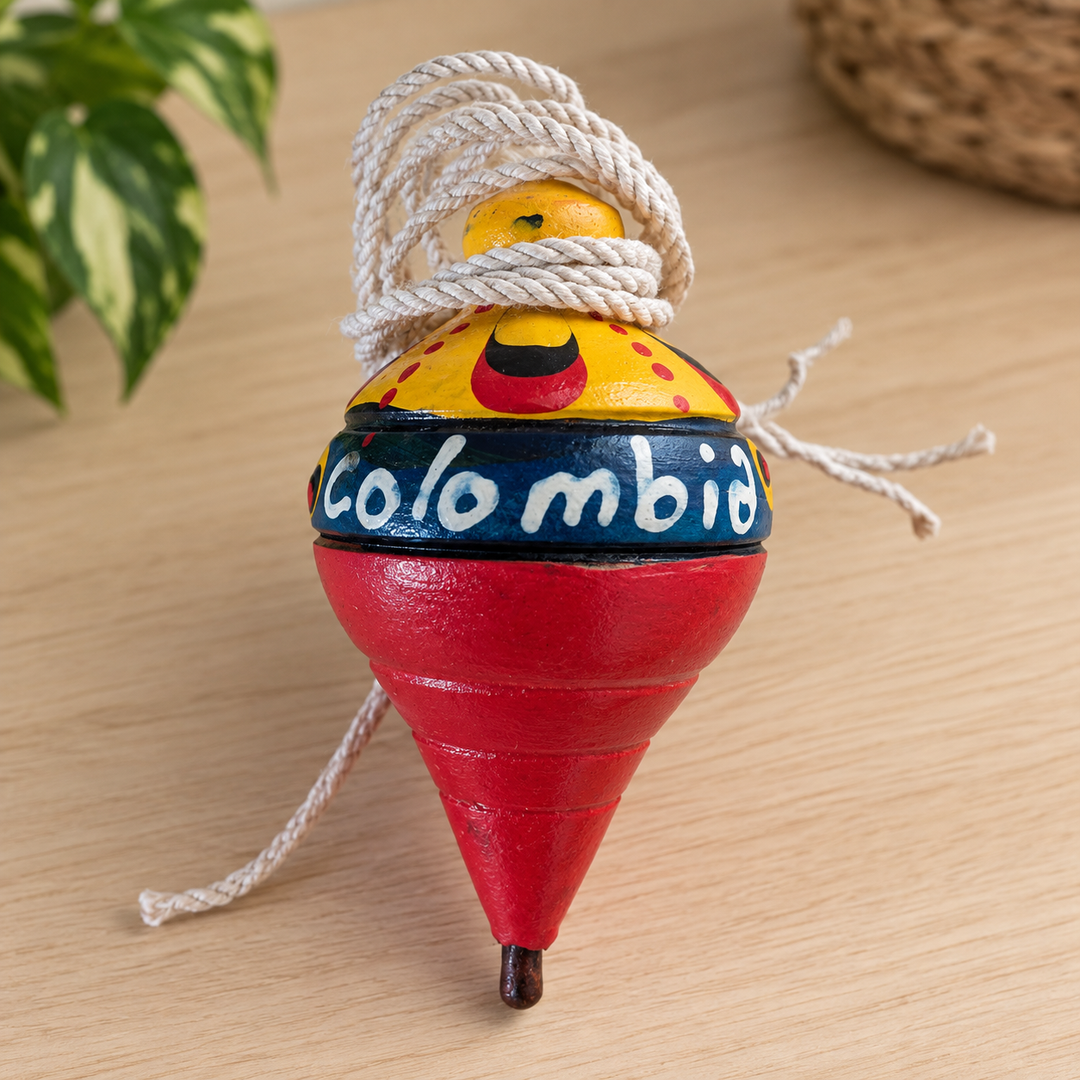 Hand-painted Colombian trompo spinning top displayed on a light wooden table