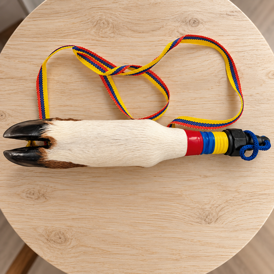 Full cowhide hoof bottle with woven Colombian color strap on light wood table